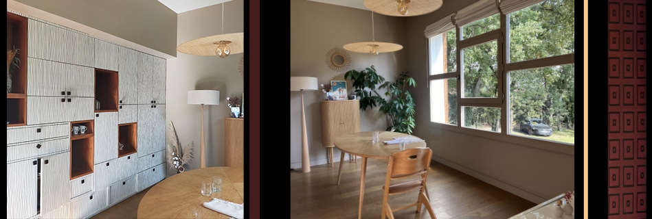 Salle à manger : rangement mural texturé blanc et bois, table ronde en bois clair et enfilade vintage devant une large fenêtre sur les arbres