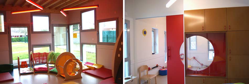 Salle de vie lumineuse aux murs rouges avec parcours de motricité, et meuble de rangement bois percé d'un hublot rouge