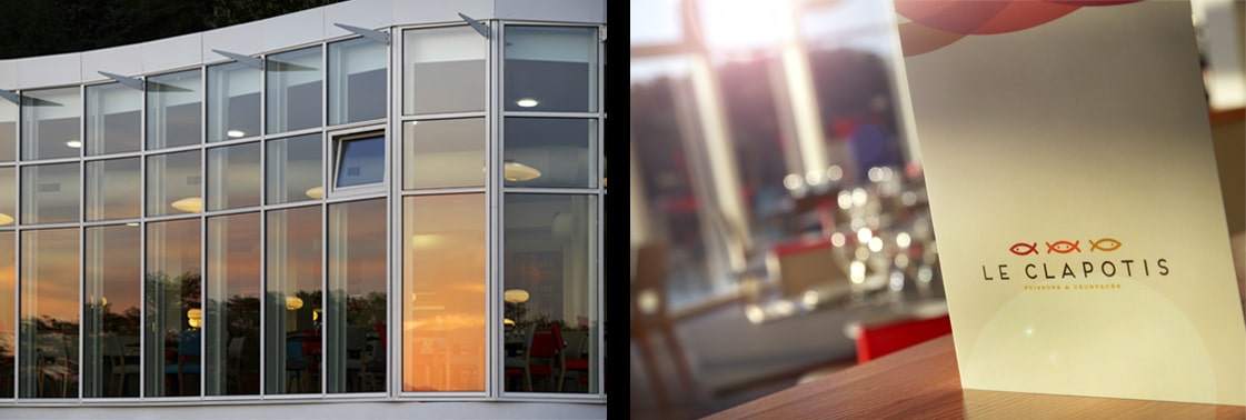 Façade vitrée courbe réfléchissant le coucher de soleil, et carte du restaurant Le Clapotis, poissons et crustacés, au logo des trois poissons