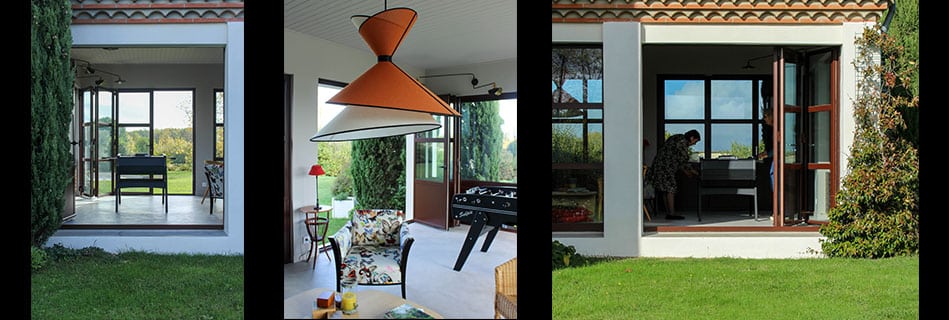 Triptyque : la pièce vitrée ouverte sur la campagne, salon détente avec babyfoot sous une suspension orange, et menuiseries accordéon repliées côté jardin